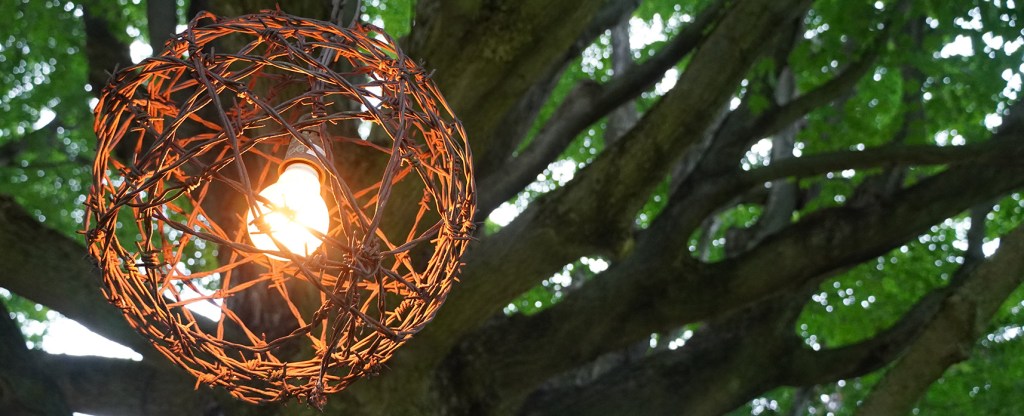 Detail of a light in a circular globe under the tree