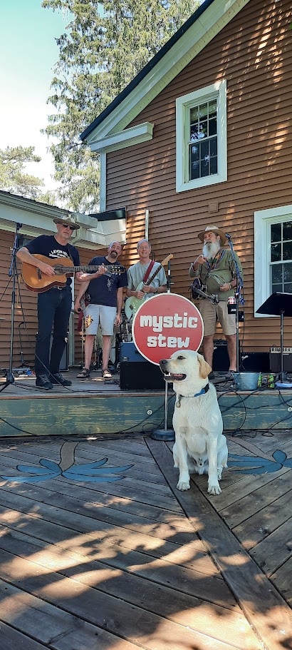 Band of 4 men posing for a picture with Finn the yellow lab
