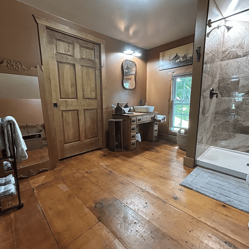 View from in the bathroom with a stone shower and a sink in the back