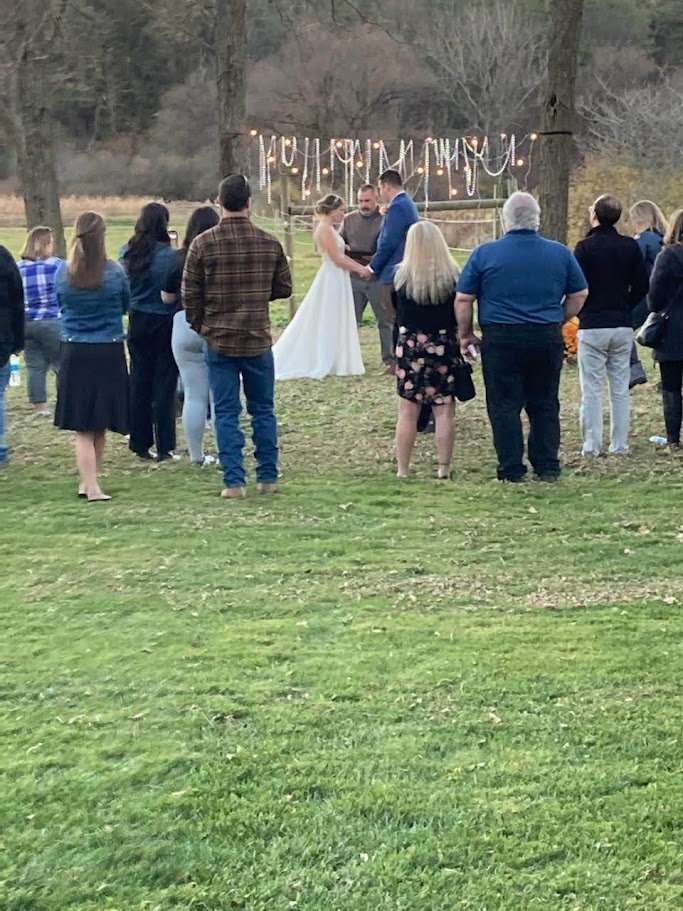 view from behind of a couple getting married with people standing and watching