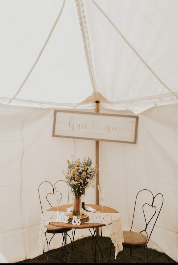 bride and groom's table under a white tent