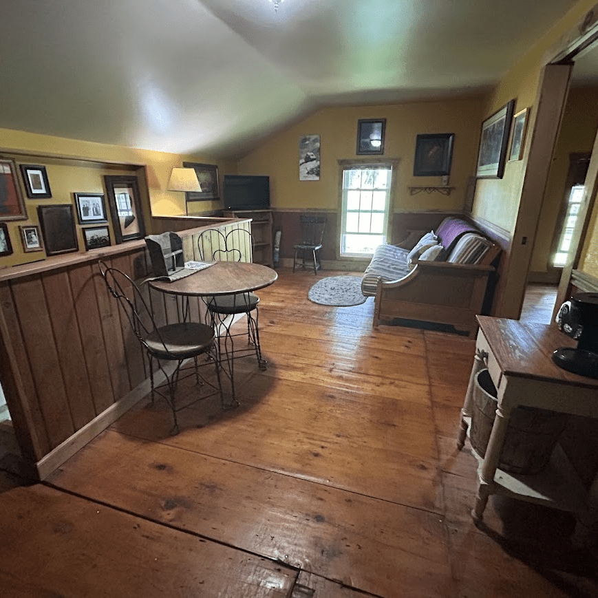 sitting area in a yellow room with a couch and a small table with two chairs