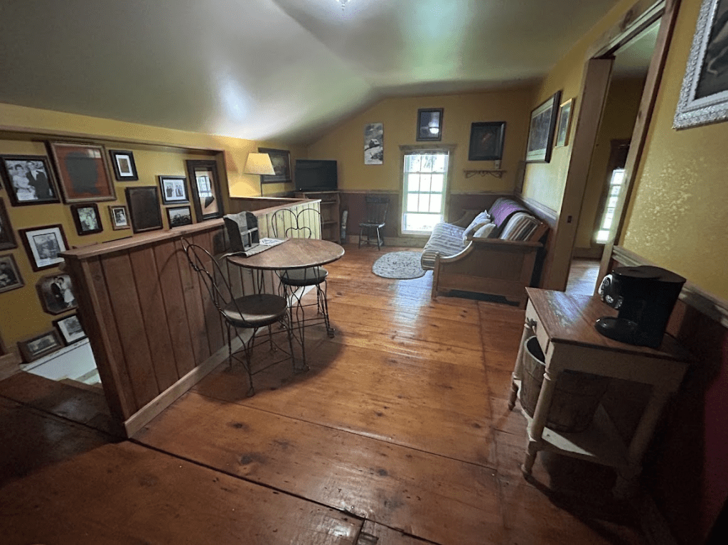 sitting area in a yellow room with a couch and a small table with two chairs